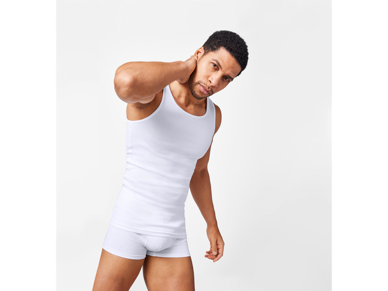 Un bărbat îmbrăcat într-un maiou și boxeri albi.