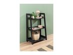 Black ladder shelf with decor, a plant, and a basket on a light wood floor.