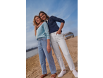 Two women in Esmara® long sleeve tops and jeans on a sandy beach.