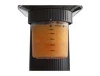 Close-up of a blender cup filled with orange liquid, showing measurement markings and lock symbols.