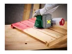 A cordless random orbital sander being used to sand a wooden surface.