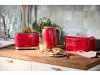 SILVERCREST® red kettle, toaster, and bread bin on a kitchen counter with a sandwich.