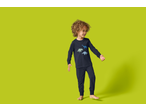 lupilu® Kids' Pyjamas: A smiling child in dark blue dinosaur pyjamas.