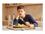 A boy looking displeased while holding a fork with broccoli on it.