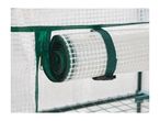 Rolled-up transparent greenhouse cover with green trim and zipper, secured by a strap.