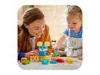 Mother and child playing with colorful building blocks on the floor.