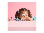 A child playing with a LEGO Friends ice cream scooter and minifigures.