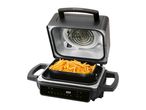 An open air fryer with a basket full of golden french fries, showing the heating element.