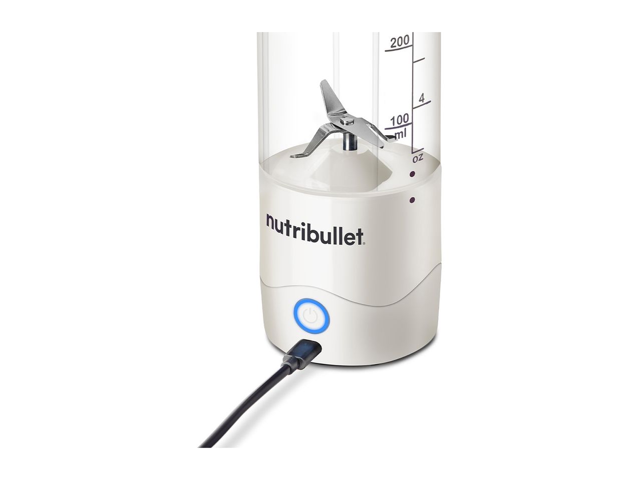 A Nutribullet baby bottle warmer and mixer is shown plugged in and partially filled with a creamy substance.