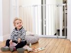 Baby near Safety 1st baby gate and toys.