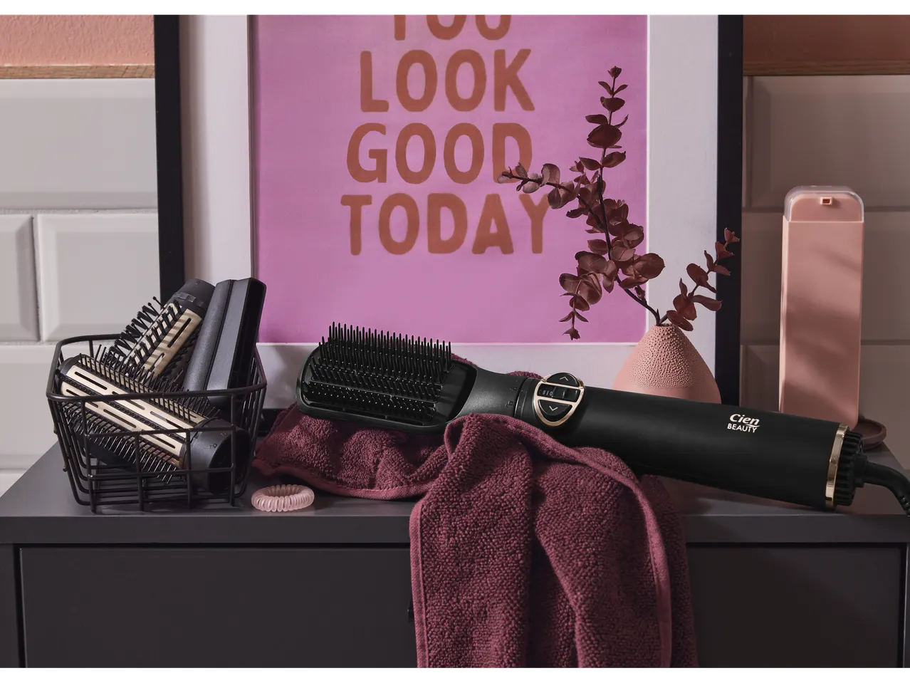 Cien Beauty rotating hot air brush on a towel, with accessories in a basket.