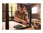 Man assembling a metal frame with a ratchet wrench and socket set on a wooden workbench.