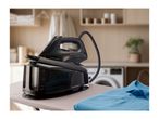 A black SilverCrest steam generator iron on an ironing board with a blue polo shirt.