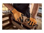 Hands in orange and black work gloves sanding a wooden crate with a sanding block.
