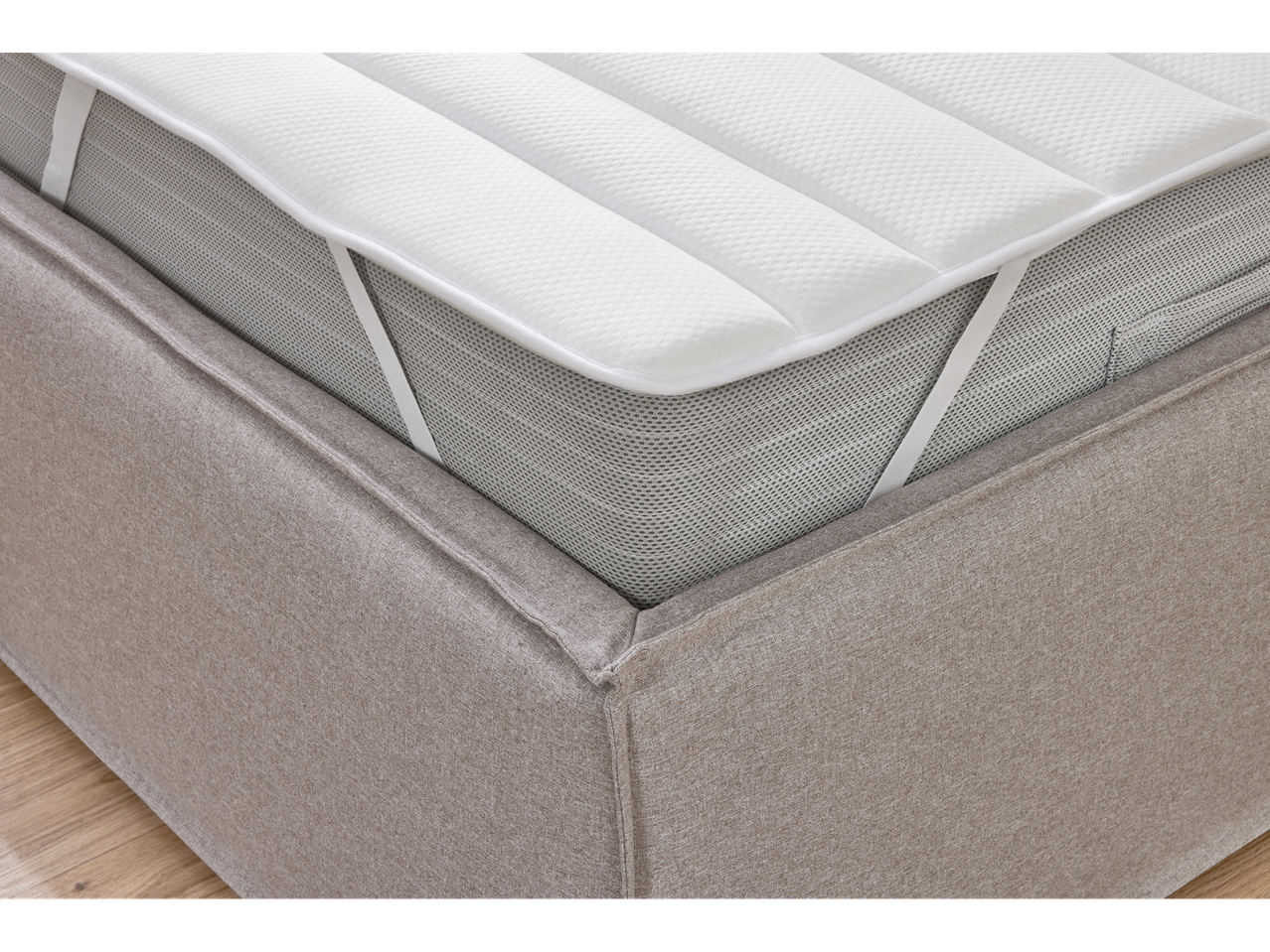 Beige mattress topper and bed base.