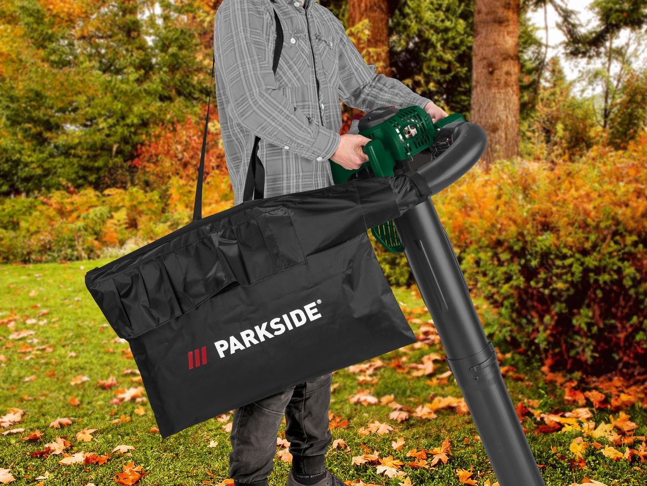 A person using a Parkside leaf blower with a collection bag in an autumn yard.