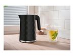 A black electric kettle with a honeycomb pattern next to a cup of hot mint tea.