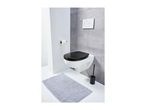 A modern bathroom with a wall-mounted toilet, black seat, and a gray bath mat.