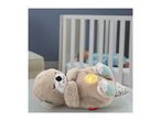 Plush otter toy with glowing belly, baby sleeping in crib in background.