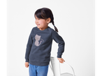 Menina com moletom azul escuro com tema de gato e jeans.