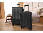 Duas malas pretas num quarto moderno, prontas para viajar.