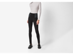 Femeie într-un pulover bej pe gât și jeggings negri modelatori.