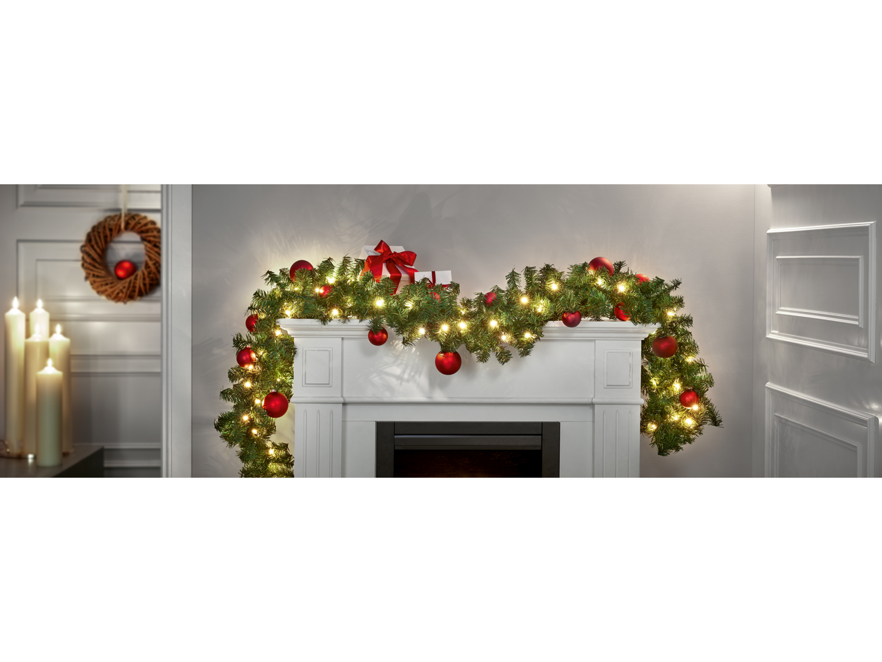 Livarno home LED-Lichterkette on a fireplace mantel with red baubles and gifts.