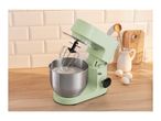 Light green stand mixer with whisked cream in a bowl, eggs, and kitchen utensils.