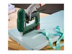 Electric stapler in use, securing light blue fabric to a wooden surface, with a polka-dot ribbon nearby.