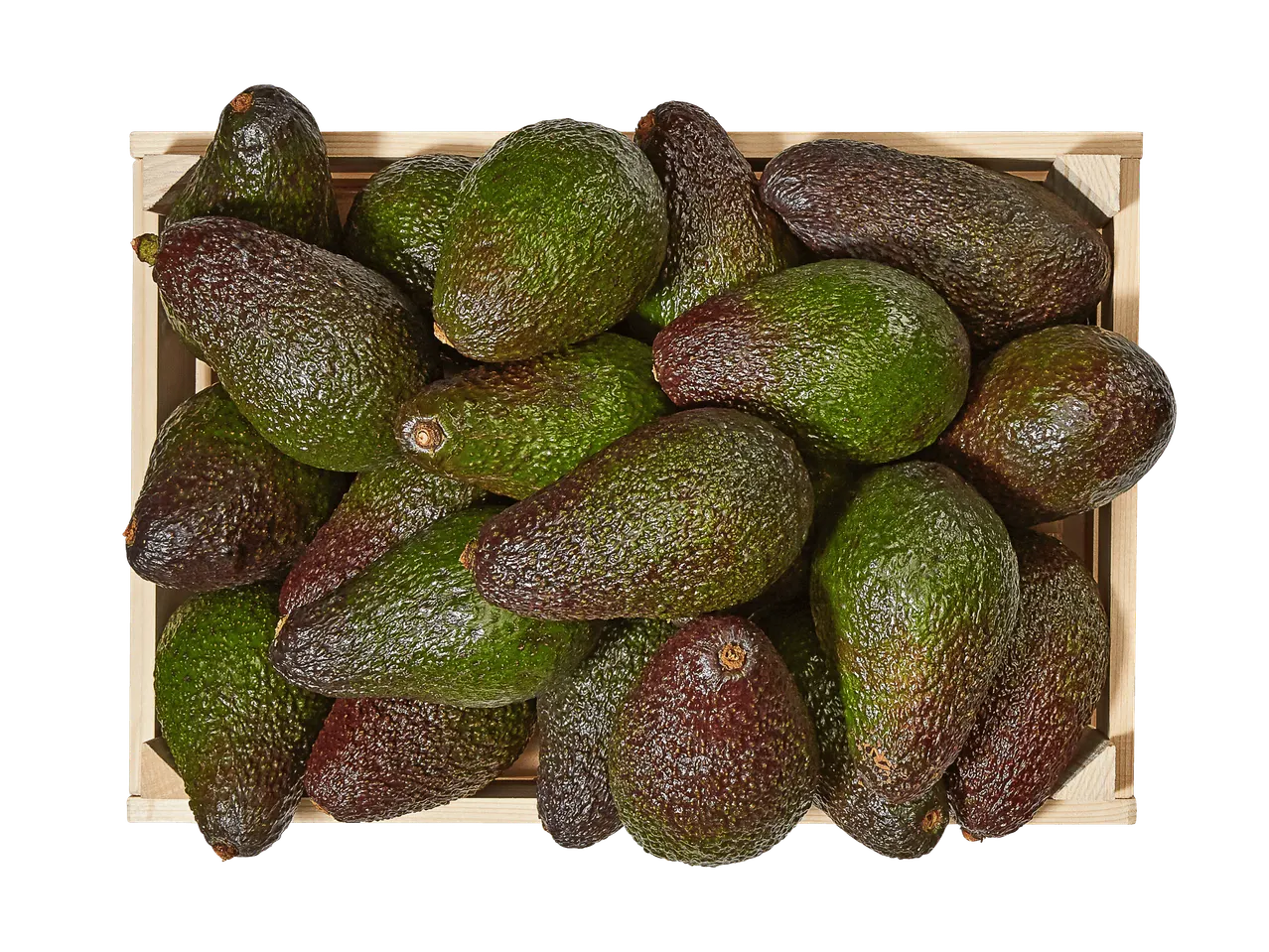 Une caisse en bois remplie d'avocats mûrs et verts sur fond noir.