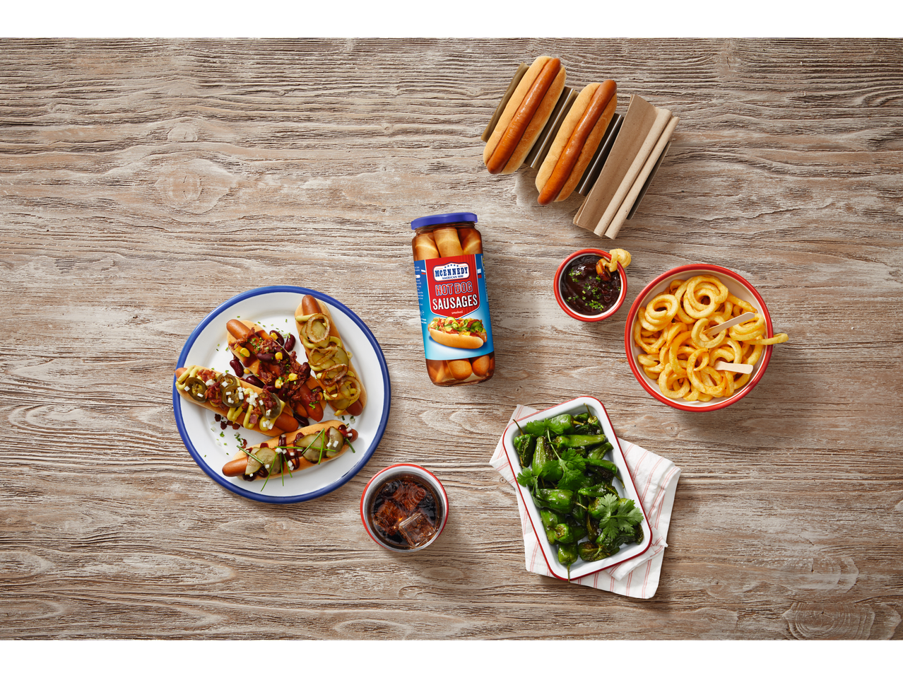 McEnnedy Hot Dog Sausages in a jar, served in buns with various toppings, curly fries, and padron peppers.