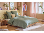 Livarno Premium Muslin Duvet Cover Set in sage green with daisy pattern on a bed in a bright bedroom.