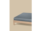 A grey fitted sheet on a light wooden bed frame against a beige background.