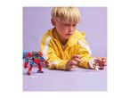 A child playing with a red and blue robot toy and a white astronaut figure.