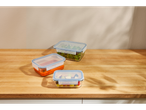 Recipiente de sticlă cu mâncare: salată, sos și fructe.