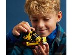 A boy holding a yellow and black toy construction vehicle.