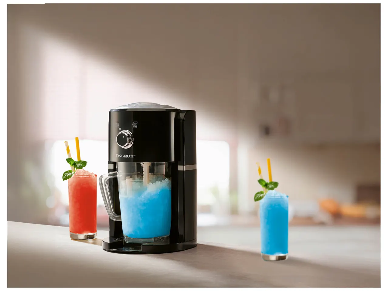 Un appareil à slush noir prépare des boissons glacées bleues et rouges.