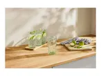 Three glasses of mojito with limes and mint on a wooden countertop.