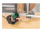 A person in work gloves uses a bench grinder to polish a metal pipe on a wooden workbench.