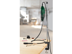 Rotary tool with flexible shaft and various accessories on a wooden workbench.