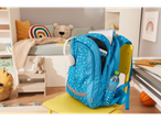 Uma mochila azul com bolinhas está em uma cadeira amarela em um quarto infantil.