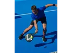 Homem a jogar padel com raquete CRIVIT e bola num campo azul.