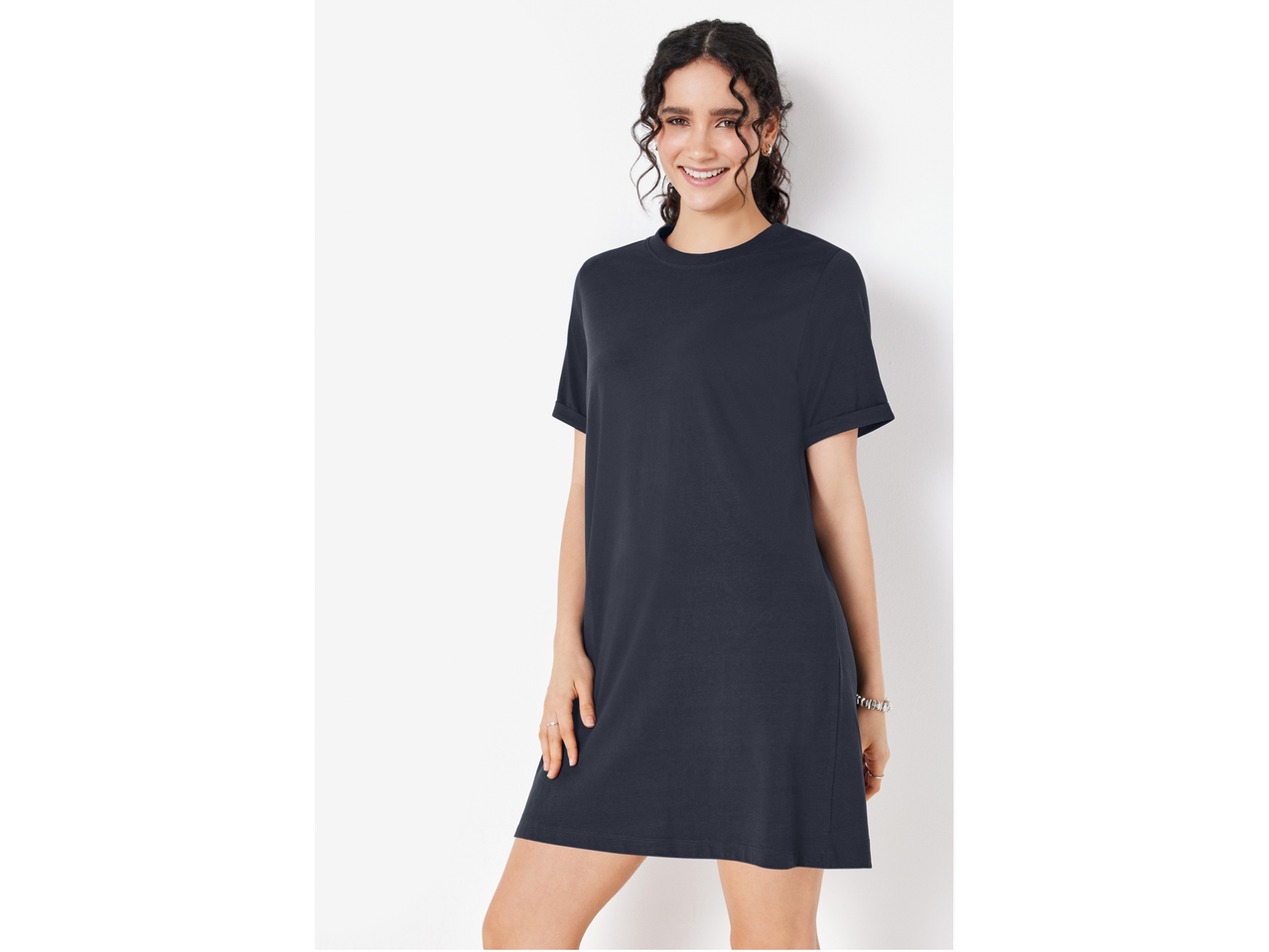 Modelka v preprosti, temno modri obleki.