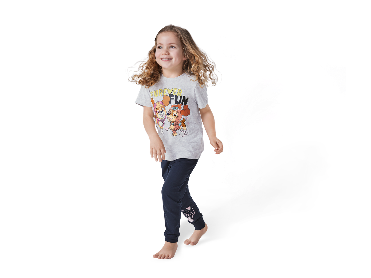 Djevojčica u pidžami Paw Patrol s sivom majicom i tamnoplavim hlačama.