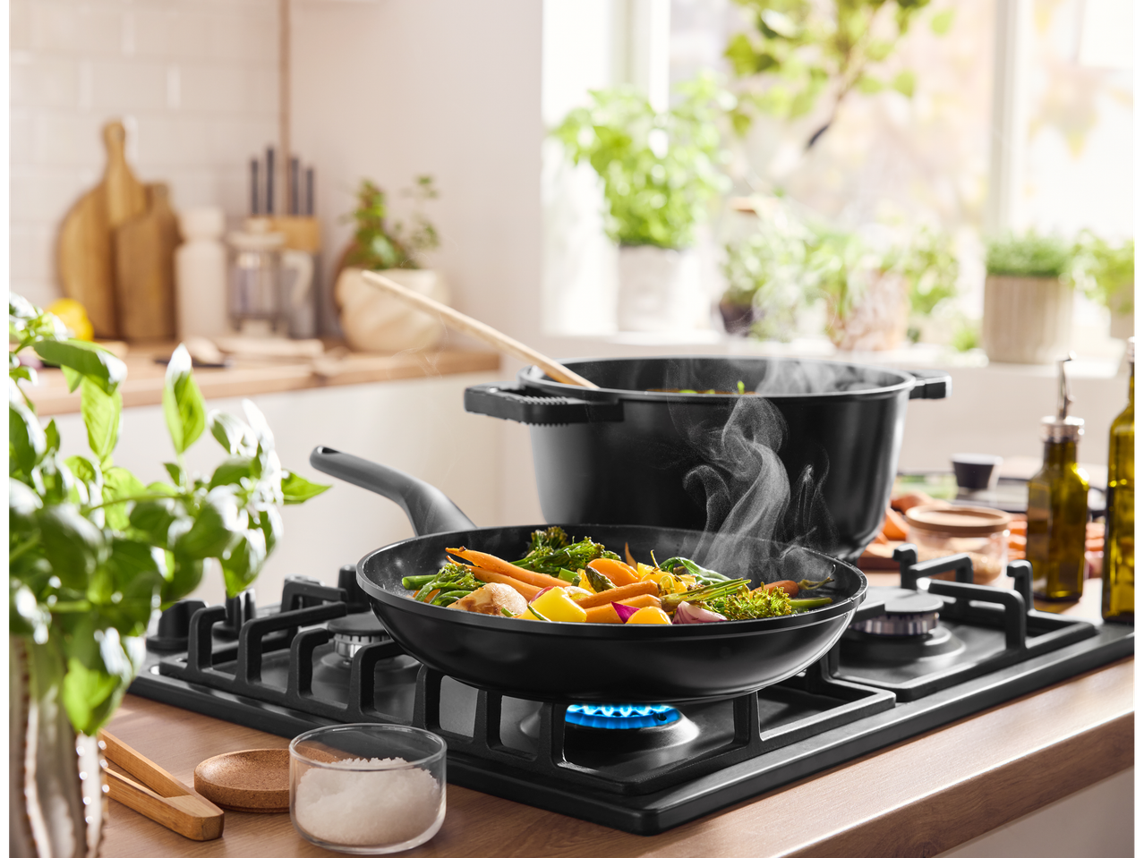 Silvercrest® alumiiniumist pott ja pann köögiviljadega, mis küpsevad gaasipliidil köögis.