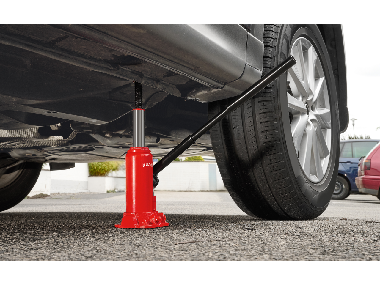 Raudonas Parkside® hidraulinis automobilinis keltuvas po pakeltu automobiliu.