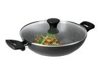 Black wok with a glass lid, containing stir-fried vegetables, on a white background.