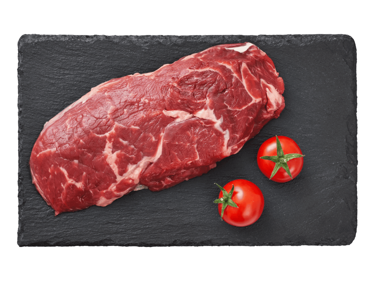 Jēla liellopa gaļas šķēle ar diviem ķiršu tomātiem uz melna šīfera dēļa.
