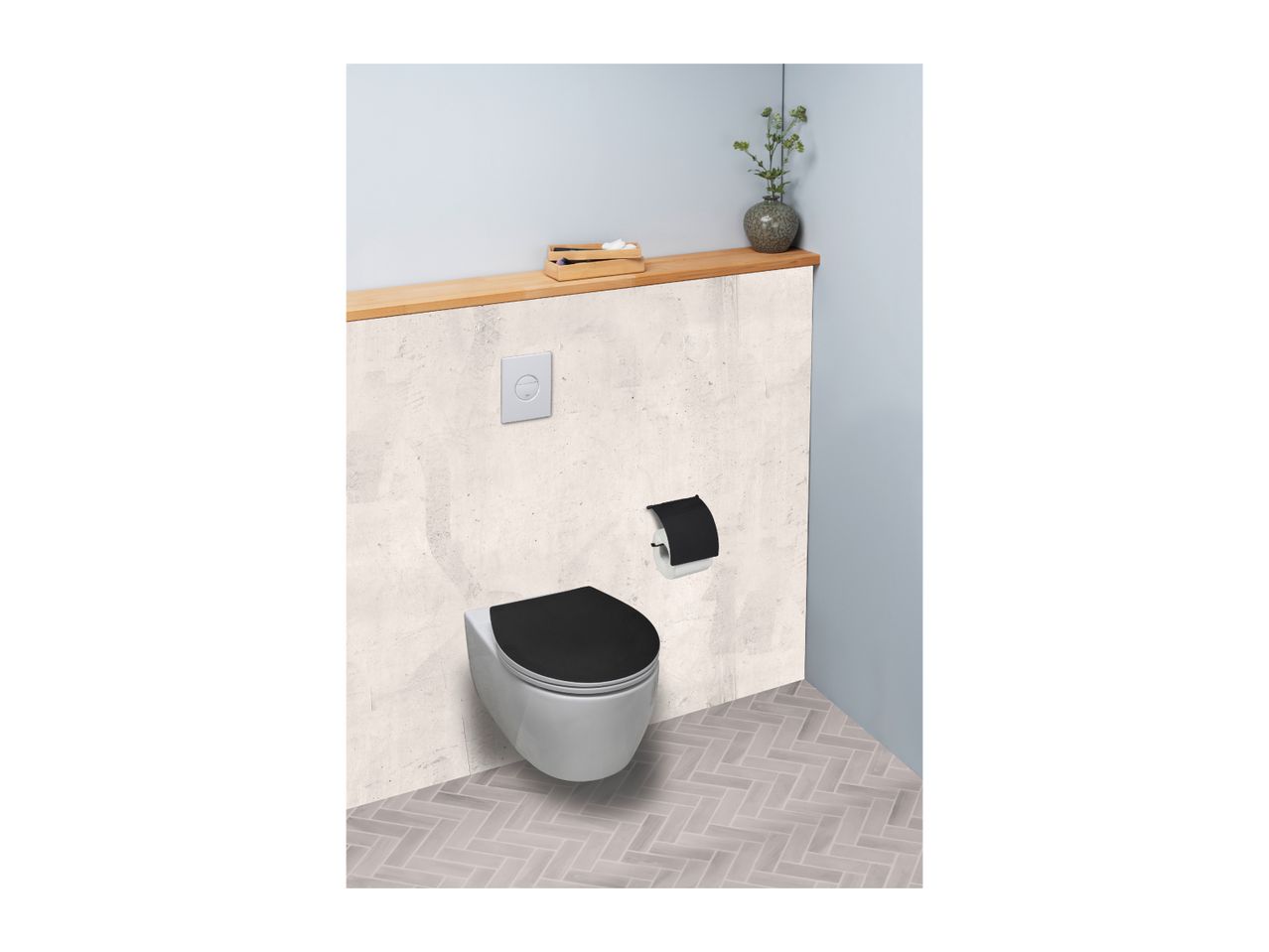 Modern toilet with black seat, flush plate, and toilet paper holder in a bathroom.