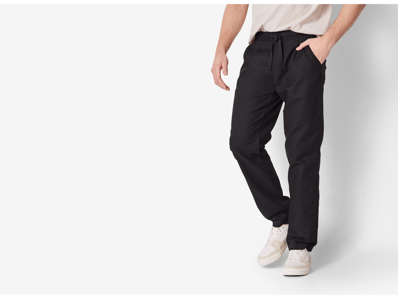 Pantaloni gri închis cu șnur și adidași albi.